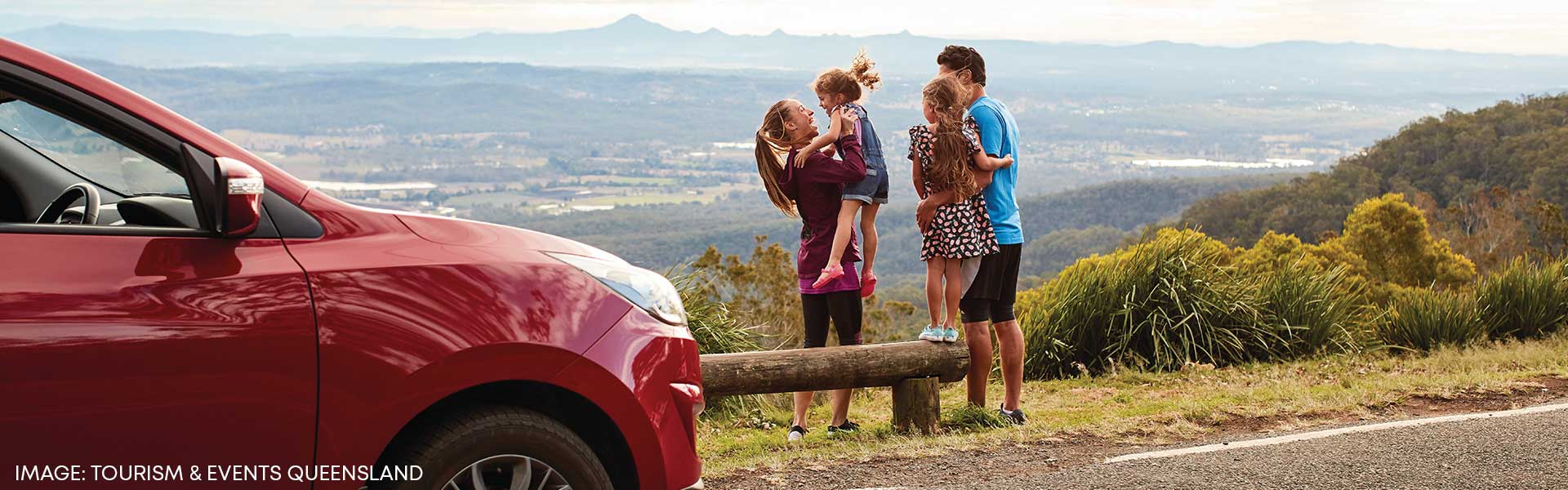 family in front of Large rental SUV in QLD